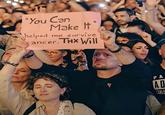 A screenshot from Will Smith's alleged AI crowd video. The audience member holds up a sign claiming Will Smith's song "You Can Make It," released in 2025, helped him survive cancer.