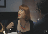 The GIF of Fred Armisen in a red wig looking around and smiling comes from the March 17th, 2016, episode of _Portlandia_, "Lance is Smart." The episode featured a sketch where Lance and Nina are at a dinner party, where Nina keeps sharing irrelevant and droll personal anecdotes. The GIF of Nina looking around the table appears at roughly the 6:44 timestamp. 