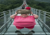 A "GIF":https://knowyourmeme.com/memes/cultures/gif version of the "AI Video":https://knowyourmeme.com/memes/cultures/ai-video of a woman breaking a glass bridge by jumping backward with a big rock.