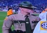 An image of a Tennessee highways patrol officer / trooper with a big chin, thick glasses and hat pulled over his eyes. He has earned the nickname Cassius Thundercock online.