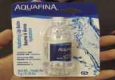 AQUAFINA. Hydrating Lip Balm Baume à lèvres hydratant Jojoba Oil Huile de Jojoba Almond Oil Huile D'Amande Vitamin E Vitamine E Net Wt./Poids Ne 5g/0.18 Oz. Distribué pour et par : Manufatured For & Distributed By:/ AQUAF Lip Bal Baume à l Net Wt./Poids Net