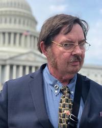 Jim Watkins at Congress wearing a Q pin