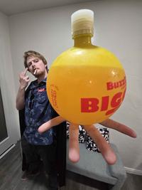 F--- You Know About This Orb reference image - a man flipping off the camera and holding a large yellow round bottle of BuzzBallz Biggies towards it