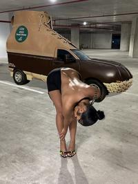 A photoshop of Rubi Rose bending over in a parking garage in front of her Cybertruck. The Cybertruck has been replaced with the Bootmobile.