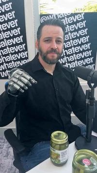 A photoshop of Andrew Wilson with a mechanical hand. The hand is perfect for opening jars of olives.