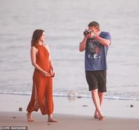 A paparazzi photo of actor "Ben Affleck":https://knowyourmeme.com/search?context=&sort=&q=Ben+Affleck taking a photo of actress "Ana de Armas":https://knowyourmeme.com/search?context=&sort=&q=ana+de+armas wearing a red dress on a beach.