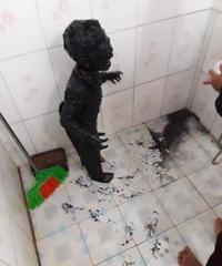 A photo of a kid covered head-to-toe in black mud. The context is that the kid fell in a puddle of mud when he got up to pee in the garden one night in Vietnam.