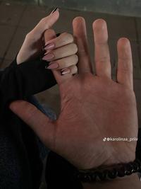 A photo of TikToker karolinaa_priiv holding her boyfriend's hand. Her hand looks tiny and his looks giant.