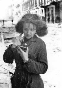 A Polish resistance fighter checks her hair after a raid, 1944