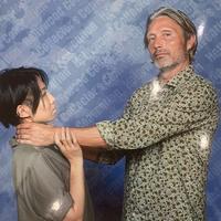 A photo of a fan requesting that Mads Mikkelsen choke them during a photo op.