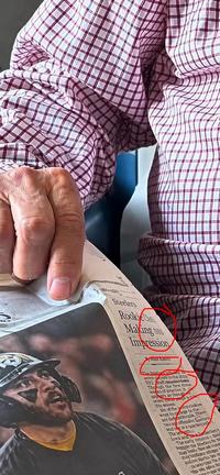 He also looks like he's pushing buttons on a tiny computer mouse embedded in the paper.