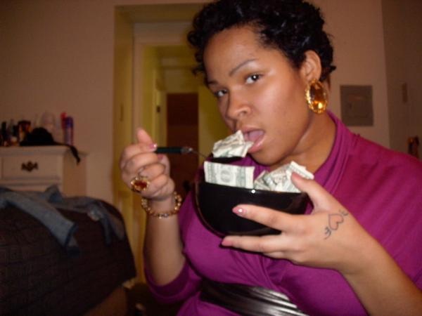 black woman wearing purple shirt eating money out of a salad bowl