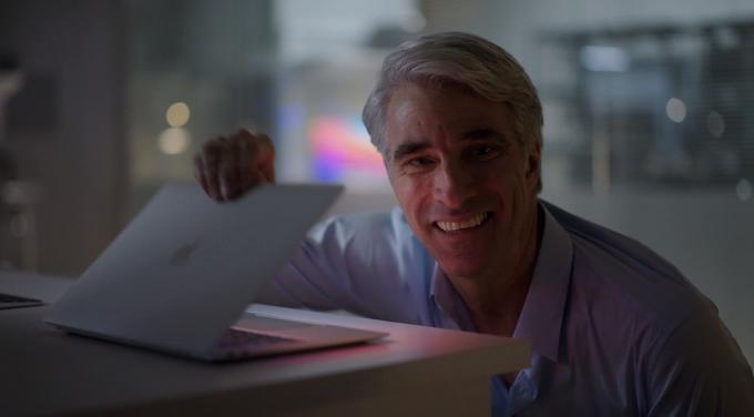 Craig Fegerighi smiling while opening a macbook