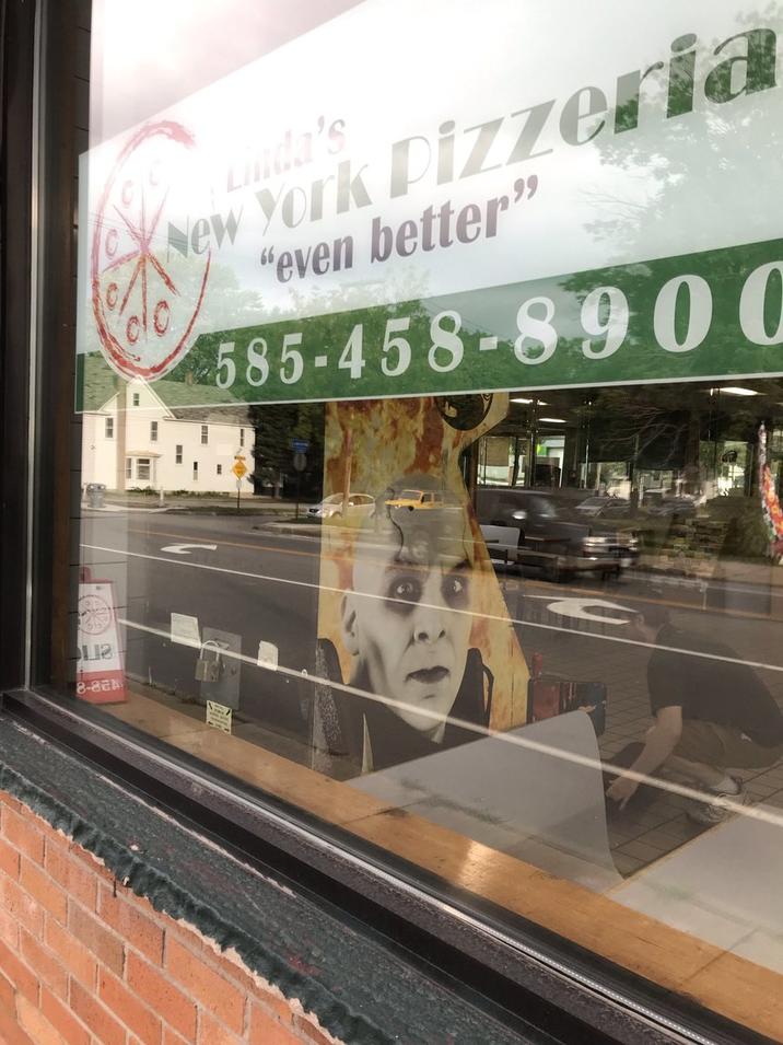 Mortal Kombat 4 arcade machine with Quan Chi on it seen from a window of a New York pizza place