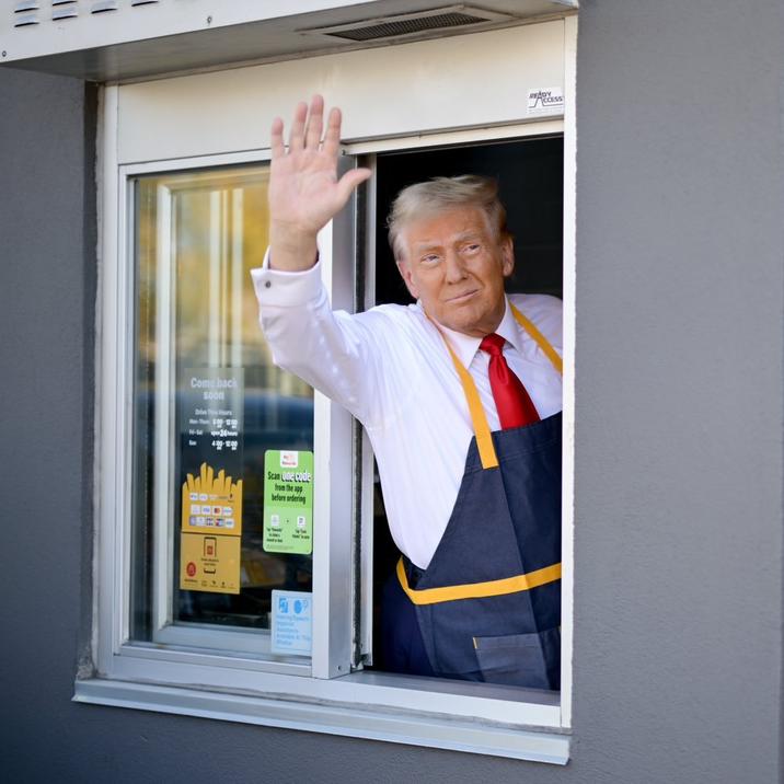 Cropped photograph of the United States presidential candidate and former president Donald Trump waving from a drive-thru window during his October 2024 photo op at a McDonald's restaurant in Pennsylvania