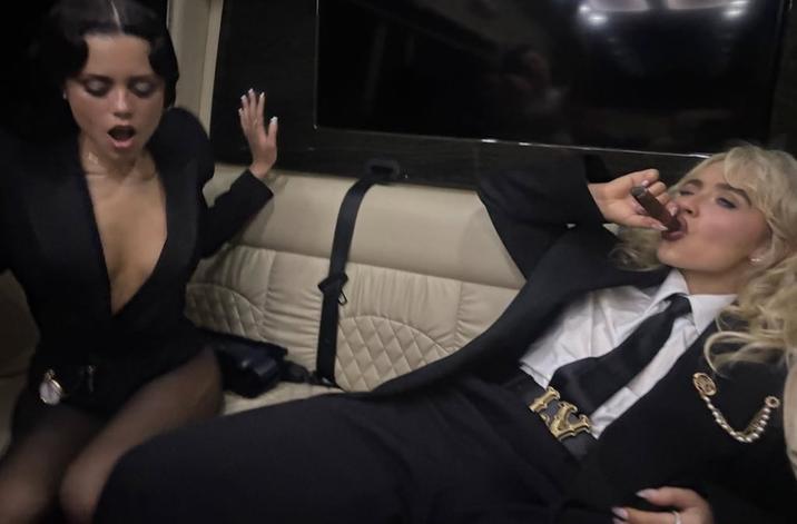 On May 7th, 2024, Sabrina Carpenter posted a slideshow of images from the 2025 Met Gala, including one showing her and actor Jenna Ortega in a limousine. Sabrina Carpenter can be seen wearing a black suit, white shirt, black tie, and "LV" best while leaning back and smoking a cigar. Jenna Ortega is shown dressed in a plunge dress while looking down and gasping. The post gathered over 2 million likes in a day. 