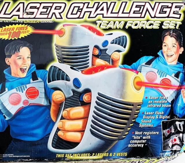 LASER CHALLENGE E ULTIMATE LASER GAME! LASER FIRES VER 100 FEET! TEAM FORCE SET וווו THIS SET INCLUDES: 2 LASERS & 2 VESTS Laser fires an invisible infrared beam Laser Flash Display & Digital Sound Systems ⚫Vest registers "hits" with computer accuracy d