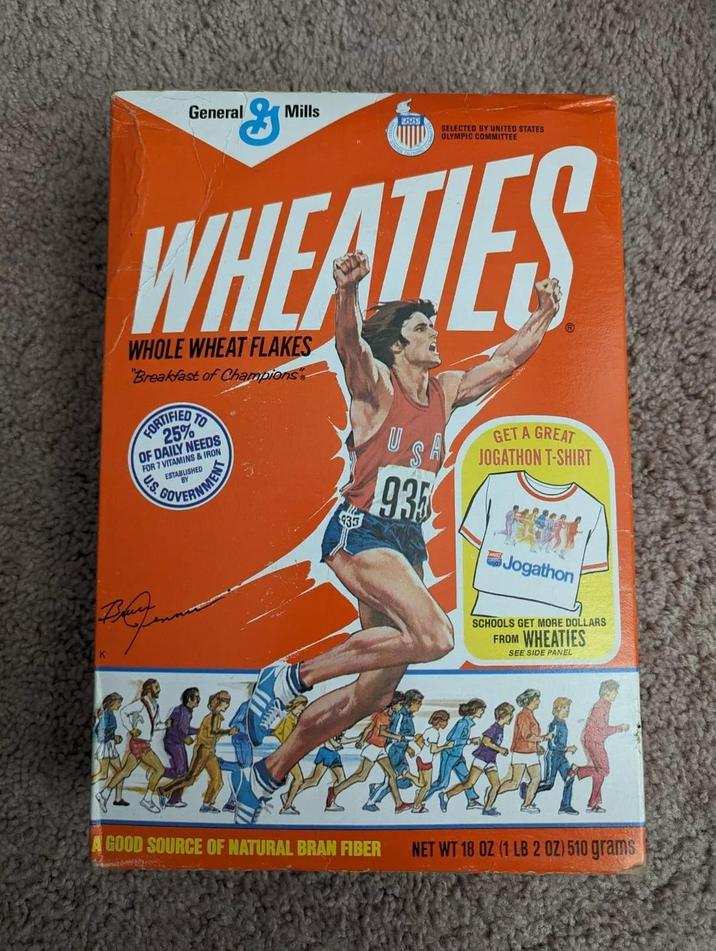 K General "G Mills 935253 SELECTED BY UNITED STATES OLYMPIC COMMITTEE WHEATLES WHOLE WHEAT FLAKES "Breakfast of Champions TO FOR 25% OF DAILY NEEDS FOR 7 VITAMINS & IRON US ESTABLISHED BY GOVERNMENT 935 GET A GREAT JOGATHON T-SHIRT Jogathon SCHOOLS GET MORE DOLLARS FROM WHEATIES SEE SIDE PANEL GOOD SOURCE OF NATURAL BRAN FIBER NET WT 18 OZ (1 LB 2 OZ) 510 grams