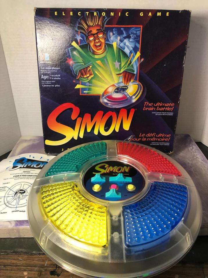 ELECTRONIC GAME Milon Bradley 1or more players Batteries required but not included. 7 to adult Age:7 7 à adulte Piles requises mais non incluses. 1 joueur ou plus SAMON SIMOR For 1 or more players CONTENTS Simon game unit 4 rubber feet, label A LOOK AT YOUR SIMON GAM vs the game parts you'll need n Figure 1 shows you learn to play Simon FIGURE 1 r switch games nd 6 for MON SIMON SIMON By Mi radley SKILL LEVEL The ultimate brain battle! CHALLENGE YOUR FRIENDS OR SOLO WITH SIMON! Le défi ultime pour la mémoire! DEFIE TES ADVERSAIRES OU MESURE-TOI A SIMON ne button ON/OFF switch ON Longest