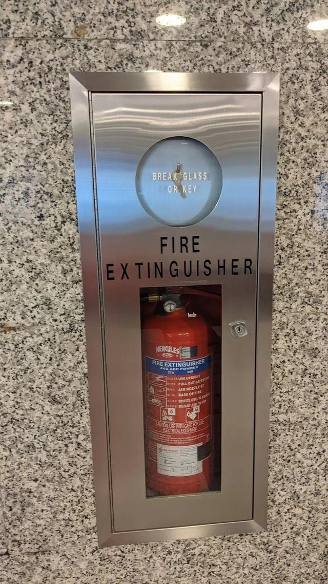 BREAK GLASS OR KEY FIRE EXTINGUISHER HERCULES FIRE EXTINGUISHER 4KG ABC POWDER 27A A USE UPRIGHT PULL OUT SAFETT AIM NOZZLE AT BASE OF FIRE RELEASE LEVE CAUTION USE WITH CARE FOR LINE ELECTRICAL EQUIPMENT