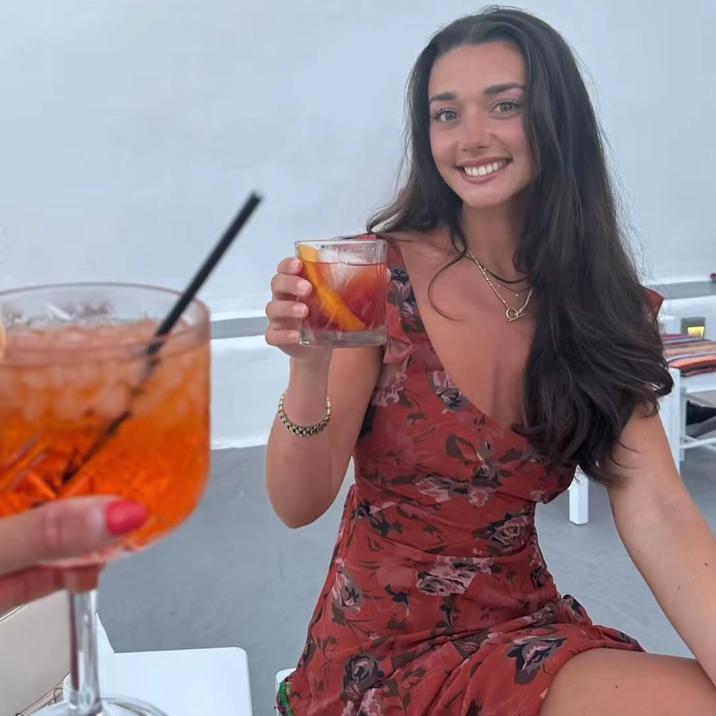 A photo allegedly of Zoe Kalotheos. She is holding a drink.