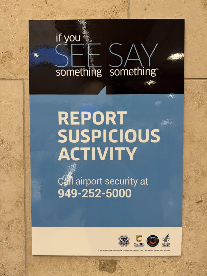 if you SEE SAY something something™ REPORT SUSPICIOUS ACTIVITY Call airport security at 949-252-5000 HOMELAND SECURITY Cal OES ORA JOHN WAYN If You See Something Say Something" used with permission of the NY Metropolitan Transportation Authority.