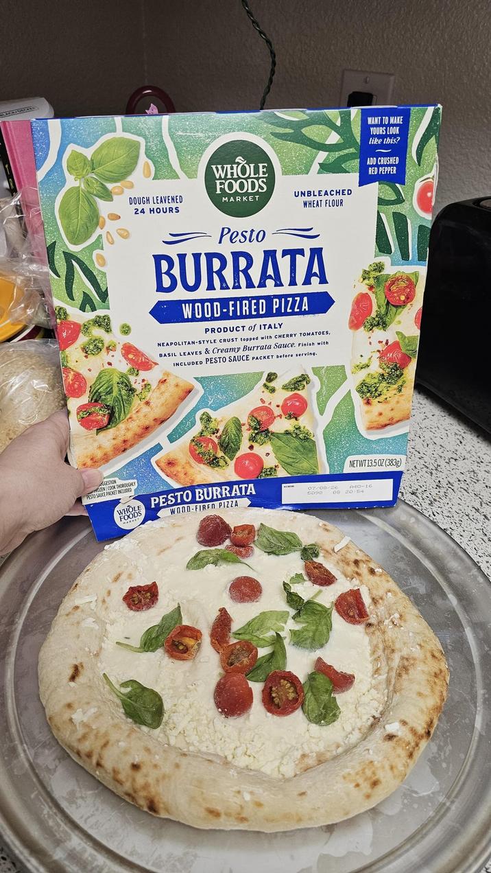 DOUGH LEAVENED 24 HOURS WHOLE FOODS MARKET UNBLEACHED WHEAT FLOUR Pesto BURRATA WOOD-FIRED PIZZA PRODUCT of ITALY NEAPOLITAN-STYLE CRUST topped with CHERRY TOMATOES, BASIL LEAVES & Creamy Burrata Sauce. Finish with INCLUDED PESTO SAUCE PACKET before serving. WANT TO MAKE YOURS LOOK like this? ADD CRUSHED RED PEPPER GGESTION ROZEN COOK THOROUGHLY PESTO SAUCE PACKET INCLUDED WHOLE FOODS MARKET PESTO BURRATA WOOD-FIRED PIZZA 07/08/26 NETWT 13.50Z (383g) A40-16 5098 68 20 54