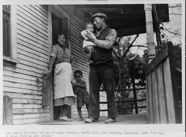 Coal miner, his wife, and two of their children, Bertha H111, Vent Virginia, September, 1938, Note logs of child standing near mother.