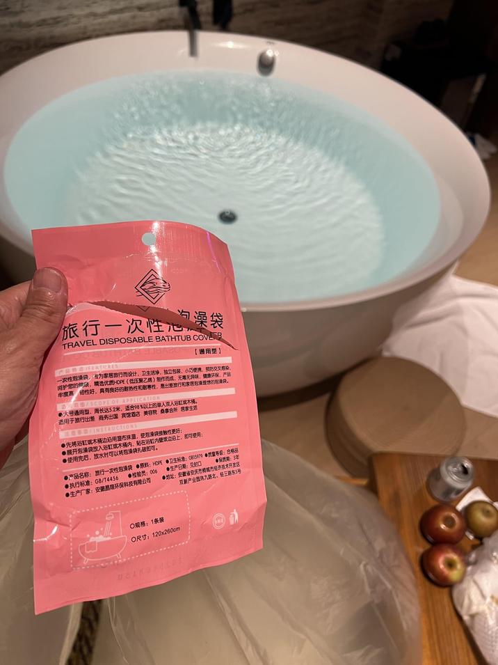 旅行一次性心澡袋 TRAVEL DISPOSABLE BATHTUB COVER 产品特点FEATURES- 【通用型】 一次性泡澡袋,专为家居旅行而设计,卫生洁净,独立包装,小巧便携,预防交叉感染, 呵护您的臂项,精选优质HDPE(低压聚乙烯)制作而成,无毒无异味,健康环保,产品 牢度高仞性好,具有良好的耐热性和耐寒性,是出差旅行和家居泡澡理想的泡澡袋。 「最范围/SCOPE OF APPLICATION ●大号通用型,周长达5.2米,适合98%以上的单人双人浴缸或木桶。 适用于旅行出差 商务出国 宾馆酒店 美容院 桑拿会所 居家生活 注意事項/INSTRUCTIONS- ●先将浴缸或木桶边沿用湿布抹温,使泡澡袋接触性更好: ●展开泡澡袋放入浴缸或木桶内,贴在浴缸内壁或边沿上,即可使用; ●使用完后,放水时可以将泡澡袋扎破即可。 ●产品名称:旅行一次性泡澡袋 ●原料:HDPE ●卫生标准:GB15979 ●质量等级:合格品 ●检验员:006 ●生产日期:见封口 ●执行标准:GB/T4456 ●生产厂家:安徽晶翔环保科技有限公司 ●保质期:5年 ●地址:安徽省安庆市橱城市经济技术开发区 双新产业园玮九路北、经三路东5号 ○规格:1条装 O尺寸:120x260cm