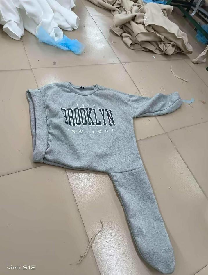 A photo of a "Brooklyn" sweater designed in a confusing way. There appears to be an arm and leg hole on the left and a massive opening on the right.