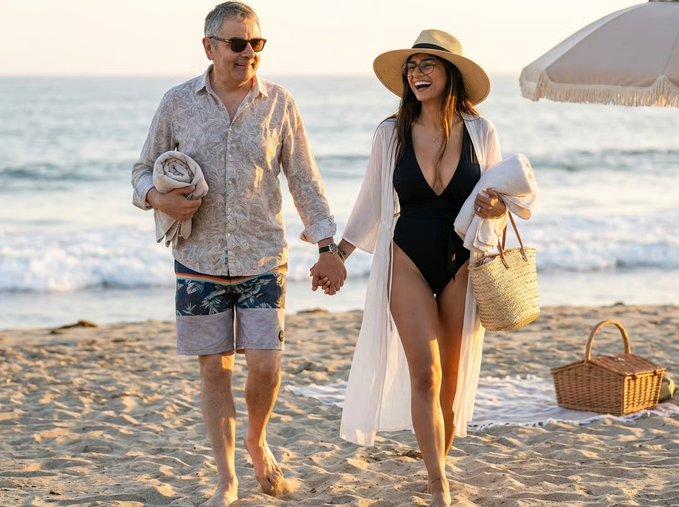An AI image of Mr. Bean holding Mia Khalifa's hand on the beach.