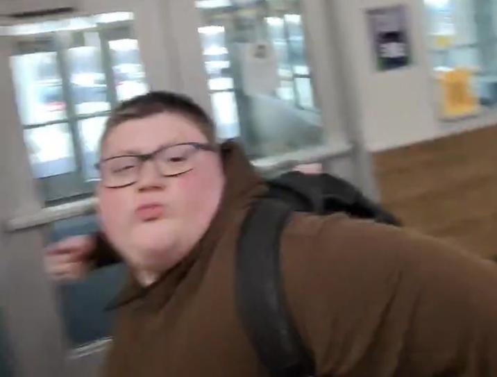 A reaction image of a kid winding up to punch someone in first person POV. It is from a video of an anti-ICE student punching a pro-ICE student.