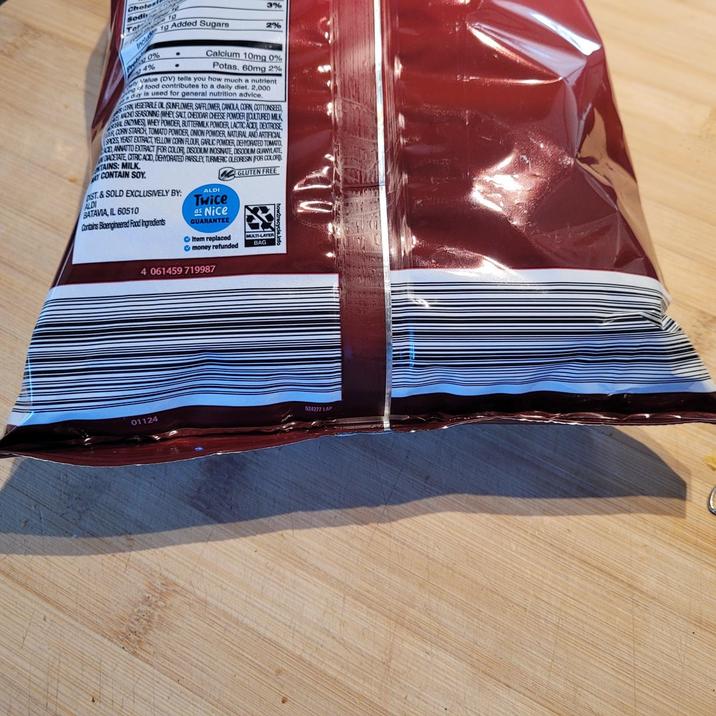 Cholest Sodi 19 10 Include 3% Added Sugars 2% $2.0% 4% Calcium 10mg 0% Potas. 60mg 2% Value (DV) tells you how much a nutrient of food contributes to a daily diet. 2,000 day is used for general nutrition advice. N VEGETABLE OIL SUNFLOWER SAFFLOWER, CANOLA CORN, COTTONSEED MANO SEASONING (WHEY SALT, CHEDDAR CHEESE POWDER CULTURED MILK L ENZYMES WHEY POWDER, BUTTERMILK POWDER, LACTIC ACID, DEXTROSE ER CORN STARCH, TOMATO POWDER, ONION POWDER, NATURAL AND ARTIFICIAL SPICES YEAST EXTRACT, YELLOW CORN FLOUR, GARLIC POWDER, DEHYDRATED TOMATO ANNATTO EXTRACT FOR COLOR, DISODIUM INOSINATE, DISODIUM GUANYLATE, DACETATE, CITRIC ACID, DEHYDRATED PARSLEY TURMERIC OLEORESIN FOR COLORD TAINS: MILK CONTAIN SOY DST.&SOLD EXCLUSIVELY BY: ALDI BATAVIA, IL 60510 Contains Bioengineered Food Ingredients ALDI Twice as Nice GUARANTEE Item replaced money refunded 4 061459 719987 GLUTEN FREE MULTI-LAYER BAG 01124 524277 LAP