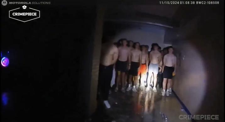 A reaction image meme of a bunch of shirtless frat pledges standing in a basement. The image comes from a video of a fire alarm response at the Alpha Delta Phi house in Iowa.