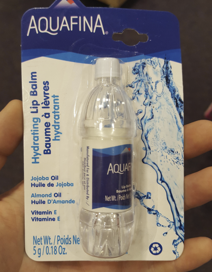 AQUAFINA. Hydrating Lip Balm Baume à lèvres hydratant Jojoba Oil Huile de Jojoba Almond Oil Huile D'Amande Vitamin E Vitamine E Net Wt./Poids Ne 5g/0.18 Oz. Distribué pour et par : Manufatured For & Distributed By:/ AQUAF Lip Bal Baume à l Net Wt./Poids Net