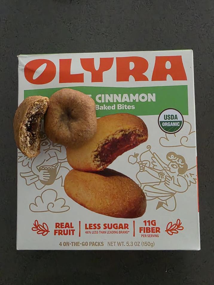 OLYRA CINNAMON Baked Bites USDA ORGANIC REAL FRUIT LESS SUGAR 46% LESS THAN LEADING BRAND 11G FIBER PER SERVING 4 ON-THE-GO PACKS NET WT. 5.3 OZ (150g)