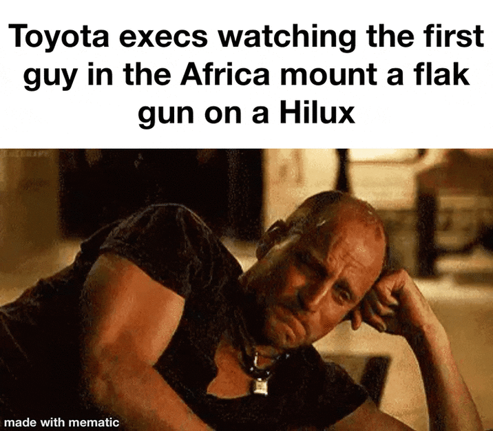 Toyota execs watching the first guy in the Africa mount a flak gun on a Hilux made with mematic