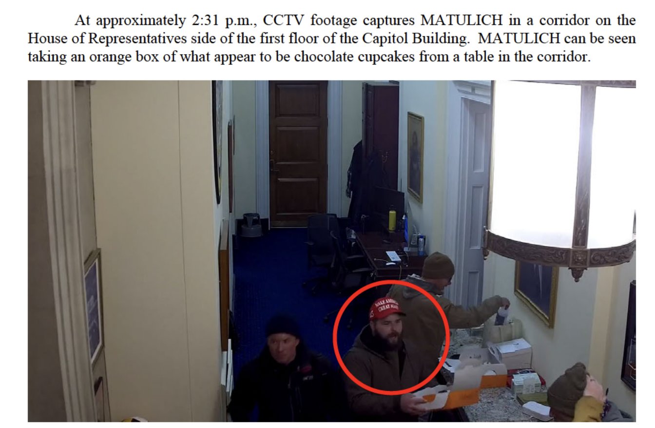 At approximately 2:31 p.m., CCTV footage captures MATULICH in a corridor on the House of Representatives side of the first floor of the Capitol Building. MATULICH can be seen taking an orange box of what appear to be chocolate cupcakes from a table in the corridor. MAKE AMO CREAT M