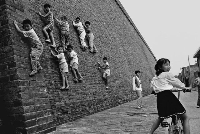 Children climbing an ancient city wall in Xi’an, Shaanxi Province, China. Photographer Hu Wugong, mi...
