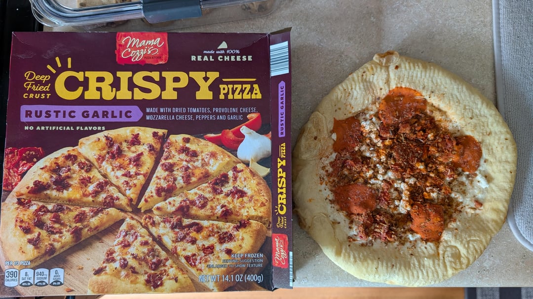 Deep Fried CRUST mama Cozzis made with 100% REAL CHEESE CRISPY PIZZA RUSTIC GARLIC NO ARTIFICIAL FLAVORS MADE WITH DRIED TOMATOES, PROVOLONE CHEESE, MOZZARELLA CHEESE, PEPPERS AND GARLIC PER 1/3 PIZZA 390 CALORIES 940 SAT FAT SODIUM KEEP FROZEN THE SUGGESTION BALARGER TO SHOW TEXTURE NET WT 14.1 OZ (400g) man CRISPY PIZZA RUSTIC GARLIC