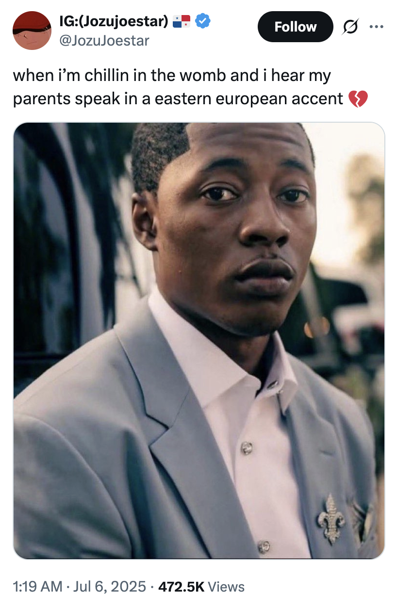 X user @JozuJoestar tweeted an image of Lil Rodney Son staring at the camera in a blue suit, writing, "when i’m chillin in the womb and i hear my parents speak in a eastern european accent 💔."