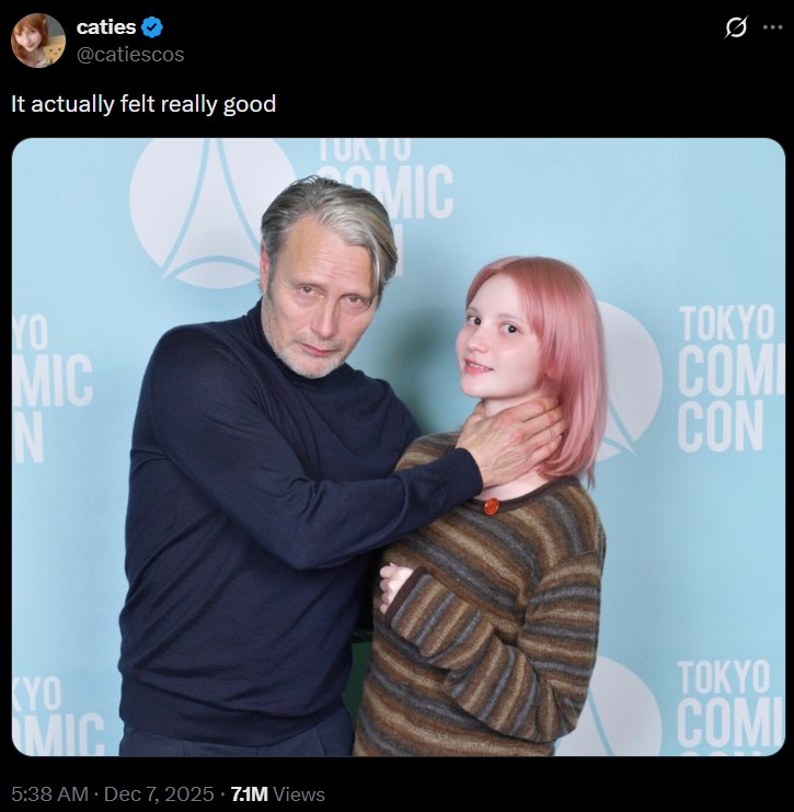 A post by Twitter user @catiescos. The tweet shares a photo of her being choked by Mads Mikkelsen and claiming it felt really good.