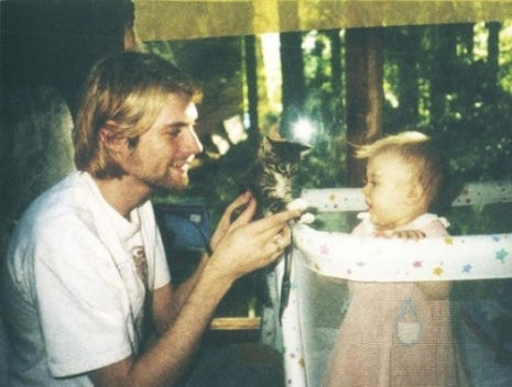 Kurt Cobain holding a kitten for his daughter, Frances, in 1993